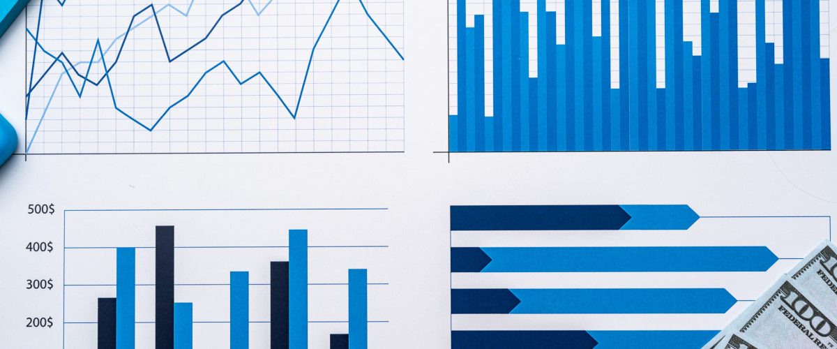 Financial paper with charts and diagrams on gray table top view